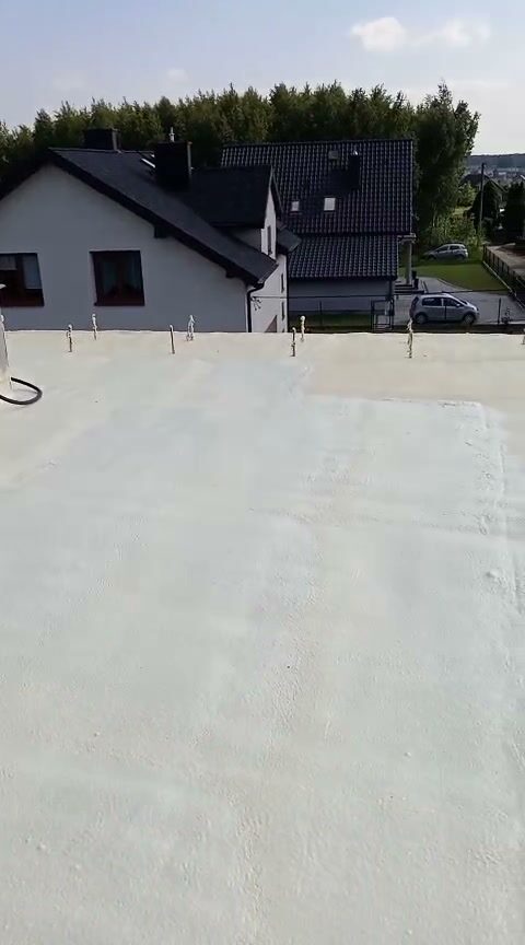 Ekipa na dachu płaskim przy gotowej warstwie piany